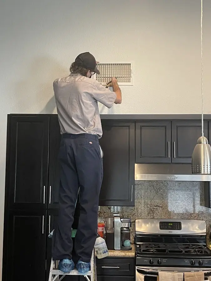 Technician inspecting an air vent during HVAC service in Huntington Park